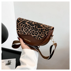 Detail of a brown saddle bag with leopard print flap and branded fabric shoulder strap