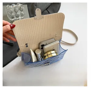 Capacity display of blue jelly crossbody bag showing storage for phone and cosmetics