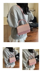 Pink French style handbag with woven texture flap and elegant wavy edges in indoor setting