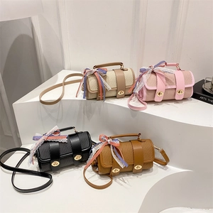 Elegant woven cylindrical crossbody bags in beige pink and black with bow ribbon detail