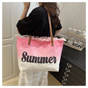 Détail du sac cabas en toile dégradé rose avec bords frangés et broderie Summer