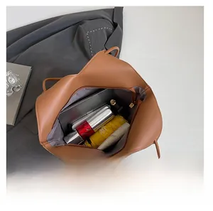 Large capacity brown tote bag interior showing storage space for tablet and umbrella