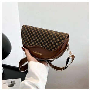 Detail of vintage monogram saddle bag with woven strap and gold metal hooks