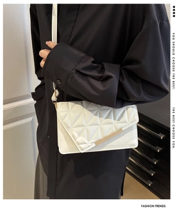 Modèle portant un sac bandoulière blanc matelassé avec détails dorés élégants