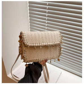 Detail of straw woven bag with shell pendants and adjustable slim leather strap