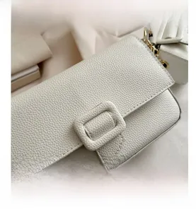 Detailed close-up of white lychee pattern leather bag with a matching square buckle