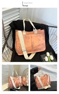 Detail of orange tote bag with bamboo leaf print and adjustable cream shoulder strap