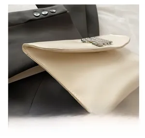 Detail shot of the cream leather handbag showing neat stitching and metallic buckle