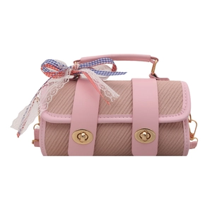 Pink woven cylindrical crossbody bag with leather trim and decorative plaid lace bow