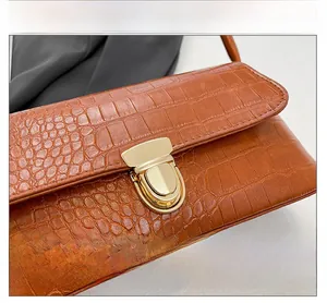 Close-up of premium brown crocodile pattern leather with shiny golden metallic lock buckle