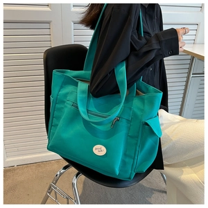 Detail of bright green canvas tote bag with front pocket and adjustable shoulder strap