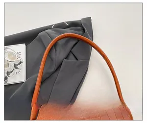 Detail of comfortable brown crocodile pattern shoulder strap on a structured handbag