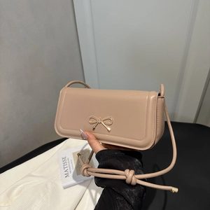 Chic beige baguette bag with gold bow clasp and knotted shoulder strap for summer 2025