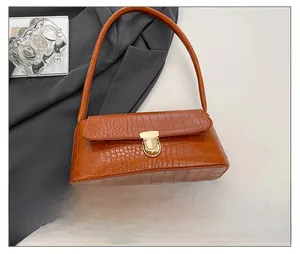 Detail of brown stone pattern leather shoulder bag with golden metallic buckle