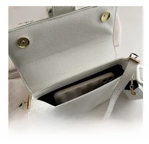 Close-up of white lychee leather bag interior showing capacity with a mobile phone inside