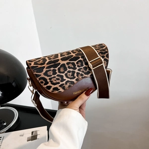 Vintage leopard print saddle bag with brown leather trim and wide striped shoulder strap