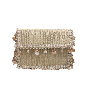 Ethnic woven straw shoulder bag with fringe, shell charms, and stylish chain strap