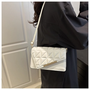 Détail d'un petit sac blanc rectangulaire avec surpiqûres géométriques et garniture en métal doré