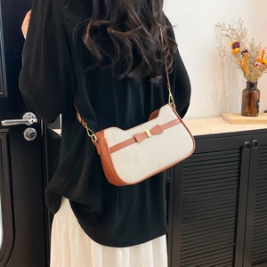 Fashionable crossbody bag in beige fabric and brown leather with a bow and gold clasp