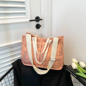 Beige tote bag with bamboo prints, dual handles, and adjustable strap in lifestyle setting