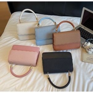 Detailed overhead view of textured woven handbags in five colors with gold hardware