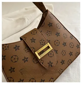 Detail of vintage brown monogram hobo bag with textured leather and gold hardware