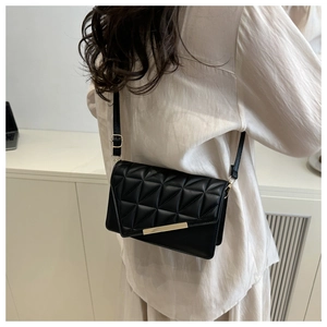 Vue détaillée du sac bandoulière noir matelassé avec boucle dorée et fine lanière