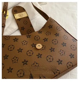 Detail of golden magnetic clasp on brown vintage leather bag with starry pattern