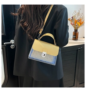 Detail view of transparent blue jelly bag with yellow flap and silver rotating metal lock