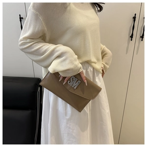 Detailed view of the tan leather small square bag featuring a sparkling rhinestone SM logo