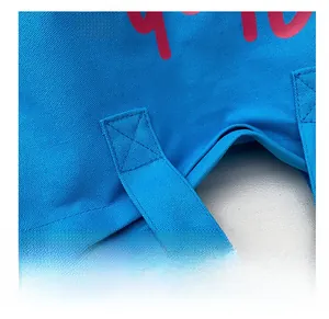 Detail of cross-reinforced stitching on bright blue canvas tote bag handle joints