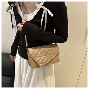 Chic beige crossbody bag with geometric quilted pattern shown on a female model