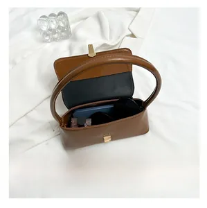 Interior storage view of brown glossy leather underarm bag with gold metal buckle