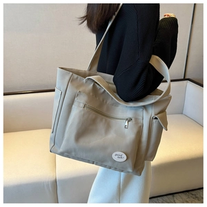Side view of large Oxford tote bag with 'good luck' label on model in minimalist room