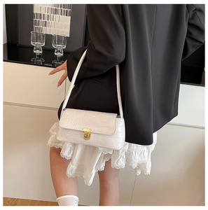 White faux leather baguette bag with crocodile texture and gold clasp on shoulder