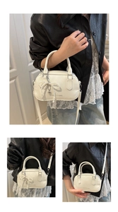 Detail of white vintage oil wax leather pillow bag with pearl bow and heart charms