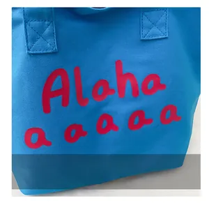 Detail of blue canvas tote bag featuring red Aloha letter print and sturdy fabric texture
