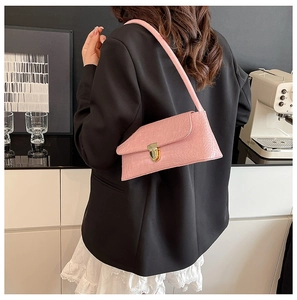 Pink faux crocodile leather shoulder bag with a gold lock shown on a model