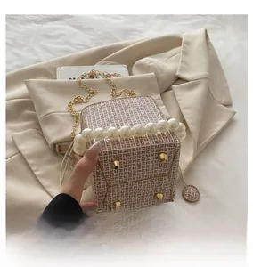 Detail of mini bucket bag showing protective base studs and pearl chain handle