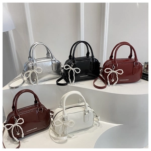 Group shot of colorful glossy pillow bags in silver, black, red, and white with pearl bows