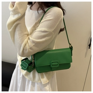 Detail of green lychee textured shoulder bag with chic mini pouch on golden chain