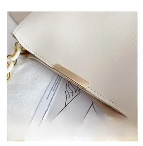 Detail of cream bucket bag showing high-quality gold hardware and chunky chain strap