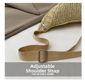 Detail of adjustable shoulder strap and metal buckle on hand-woven straw tote bag