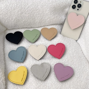 Leather heart-shaped phone socket grip set in 10 colors with embossed text on fur background