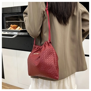 Dettagli della borsa a secchiello intrecciata con coulisse e placchetta in metallo dorato