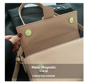 Detail of golden magnetic snap closure on premium pebbled leather shoulder bag