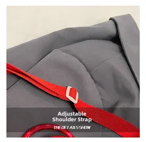 Detail of adjustable red woven strap with off-white buckle on a gray denim tote bag