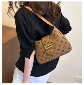 Close-up of vintage floral print brown shoulder bag with elegant gold metal buckle detail