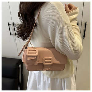 Detail of dusty pink shoulder bag with lychee grain texture and gold chain coin pouch