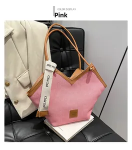 Detail of pink woven tote bag with V-shaped opening and brown leather trim accents
